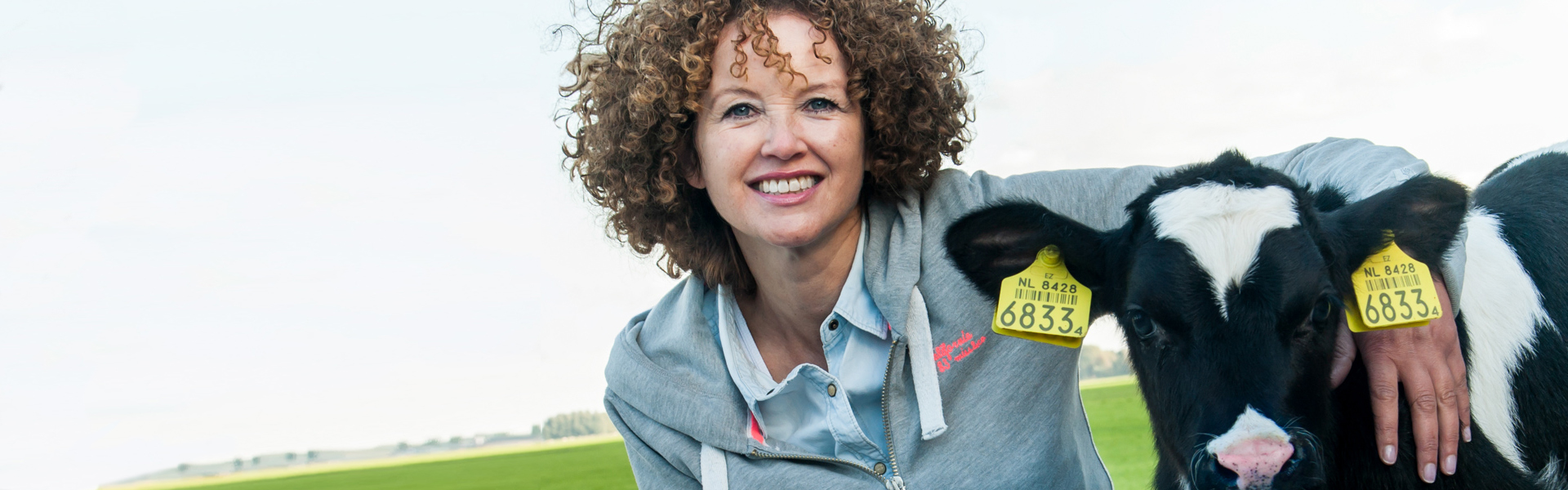 Woman with a calf in grassland