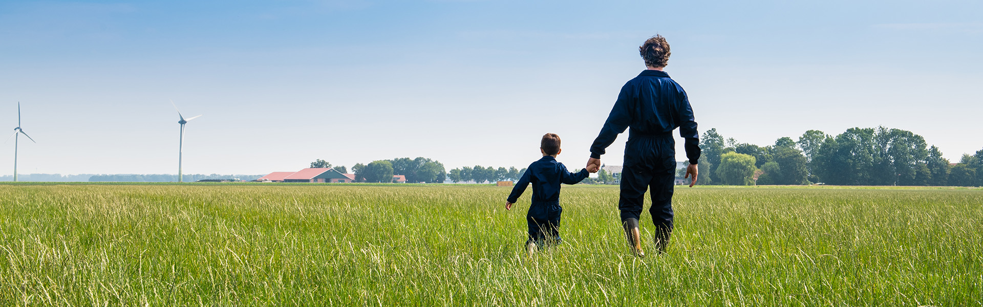 father and son walking in grassland